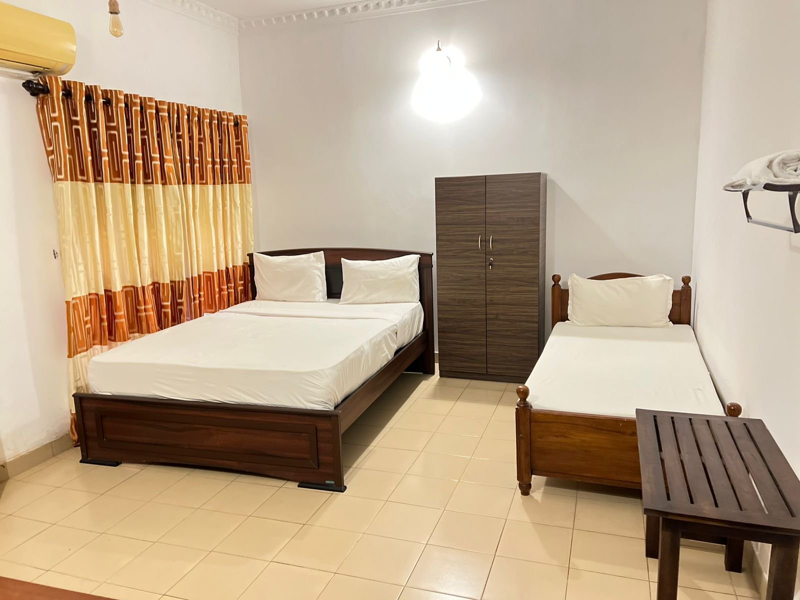 Clean standard hotel room with queen bed and white linens